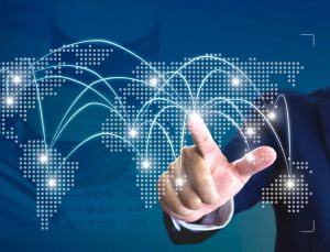 Main de l'homme pointant sur la carte du monde numérique avec des emplacements sur la carte rougeoyant